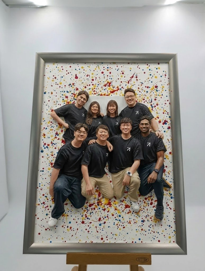 The same group recreated as a framed 3D splatter-paint art piece on an easel
