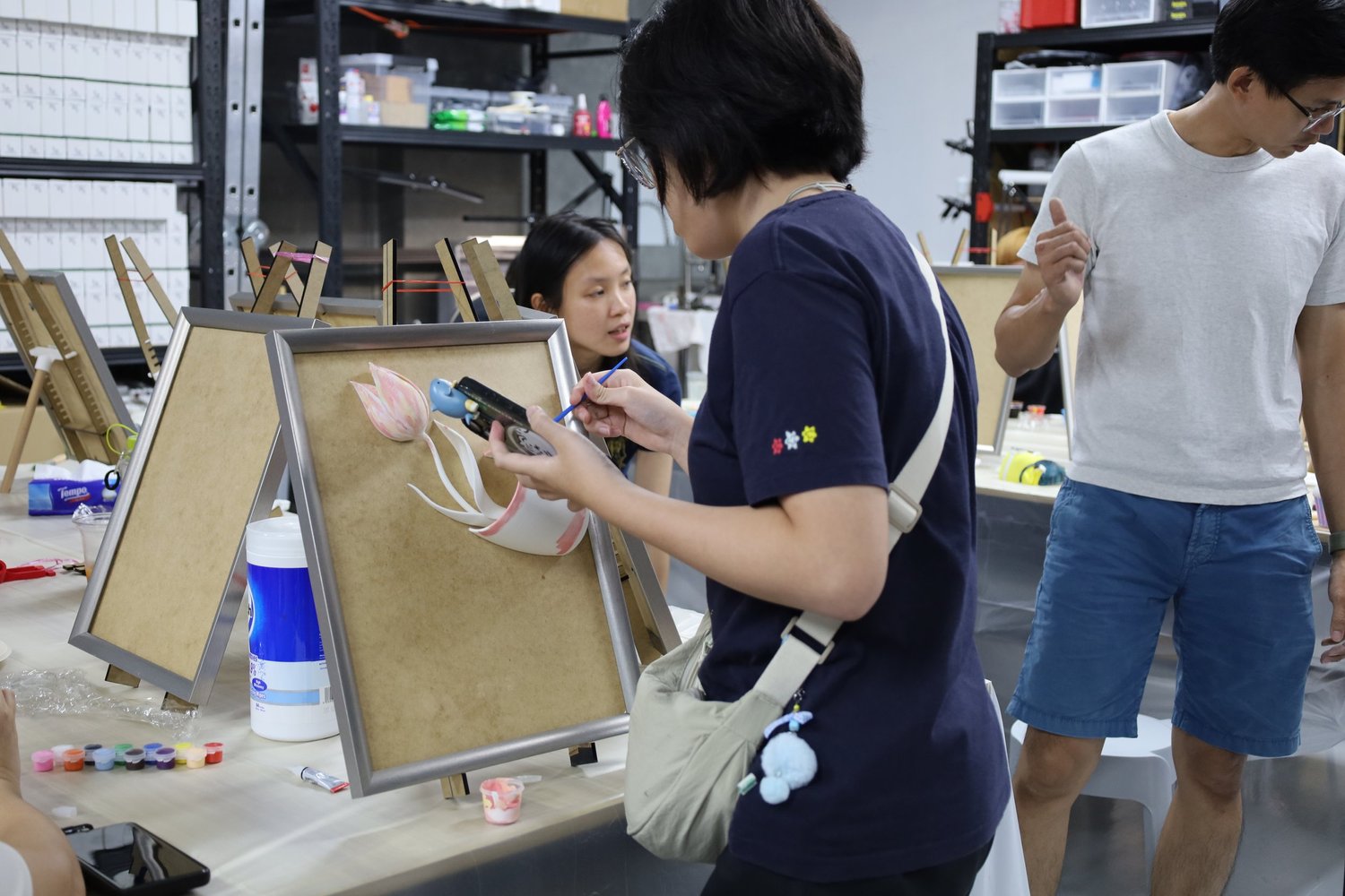A guest carefully painting a 3D tulip on canvas