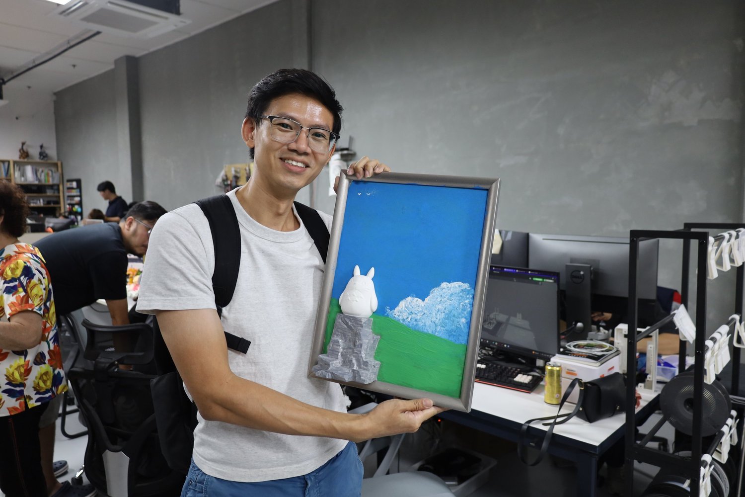 A guest holding up a finished Totoro canvas