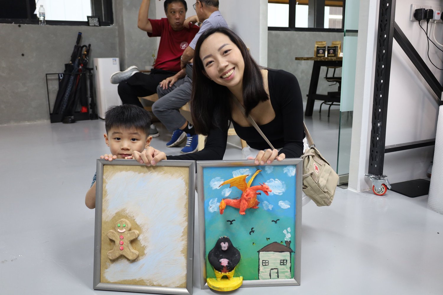 Two guests holding their finished 3D canvases at a group session